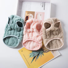 cat sweaters placed on top of some magazines