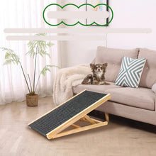 Chihuahua sitting on a sofa beside an adjustable wooden dog ramp with a black non-slip surface
