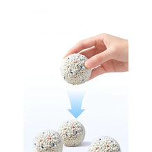Hand holding a compact ball of bentonite cat litter, showing the strong clumping performance of the granules