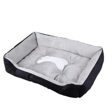Black and grey cushioned dog bed with raised sides, a padded base and a white bone-shaped centre detail