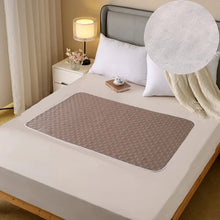 Brown quilted waterproof bed protector pad with textured surface and rounded edges shown on a mattress