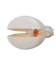 Close-up of a portable dog poop scooper with serrated jaws and spring-loaded grabber mechanism