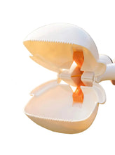 Close-up of portable dog poop scooper with wide serrated jaws and spring-loaded grabbing mechanism