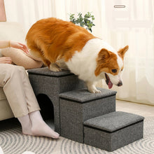 Dog using grey fabric pet stairs beside a sofa, with padded steps and a built-in enclosed pet house