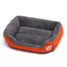 Orange and grey plush dog bed with raised cushioned sides, a soft padded base and white paw print detail
