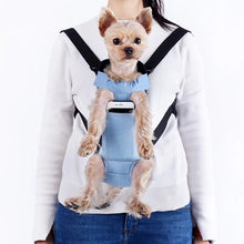 a gir wearing a blue pet backpack with a dog