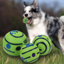 wobble wag giggle ball with dog chewing a ball on background