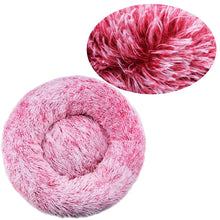 Pink fluffy donut dog bed with a soft faux fur surface, raised outer edge and close-up detail of the long plush fibres