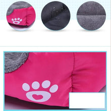 Close-up of a pink and grey plush dog bed showing soft fleece lining, water-resistant outer fabric and white paw print detail