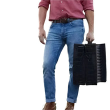 Person carrying a compact black folding dog ramp with built-in handle for easy transport and storage