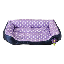 Purple polka dot cushioned dog bed with raised padded sides, a soft base and a small flower detail