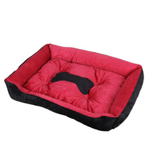 Red and black cushioned dog bed with raised sides, a padded base and a black bone-shaped centre detail
