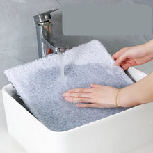 Washable grey pet stair cover being rinsed under a tap for easy cleaning