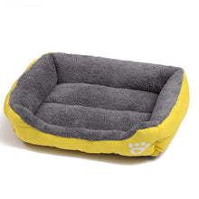 Yellow and grey plush dog bed with raised cushioned sides, a soft padded base and paw print detail